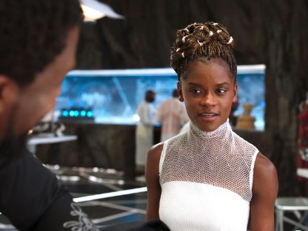Shuri wearing a white dress shares a conversation with T'Challa